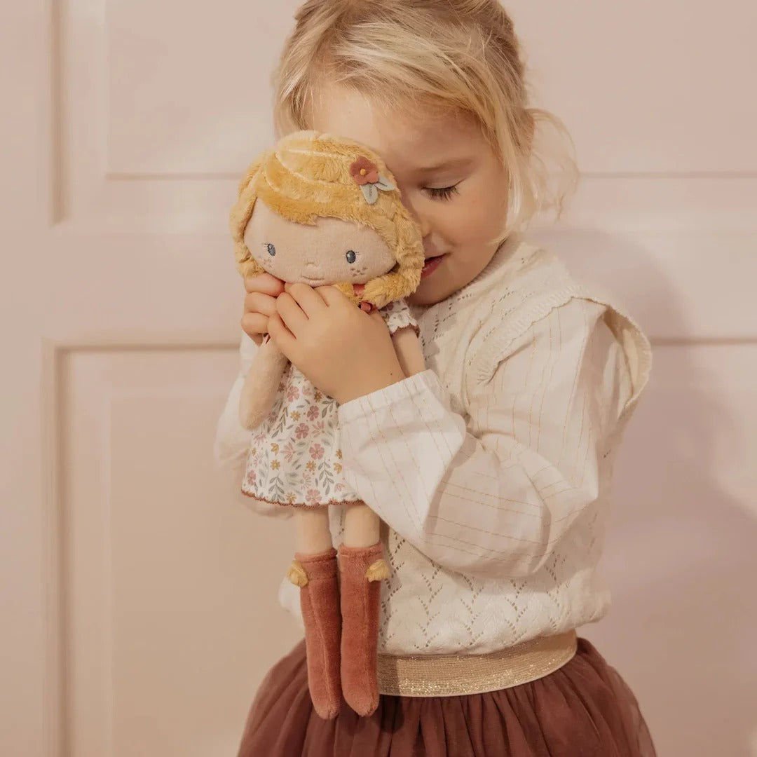Child holding a doll with a soft focus background