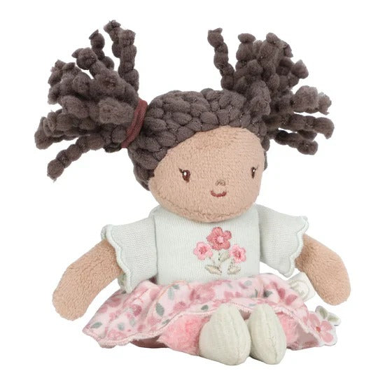 Plush doll with braided hair wearing a white shirt with a floral design and a pink skirt on a white background