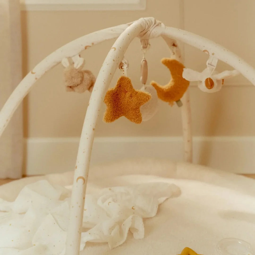 Baby crib mobile with star and moon shapes in a soft, neutral setting