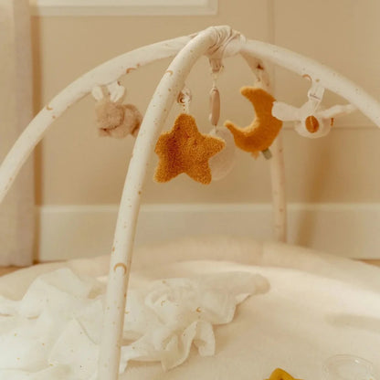 Baby crib mobile with star and moon shapes in a soft, neutral setting
