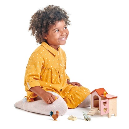 Child in a yellow dress playing with toys on a white background
