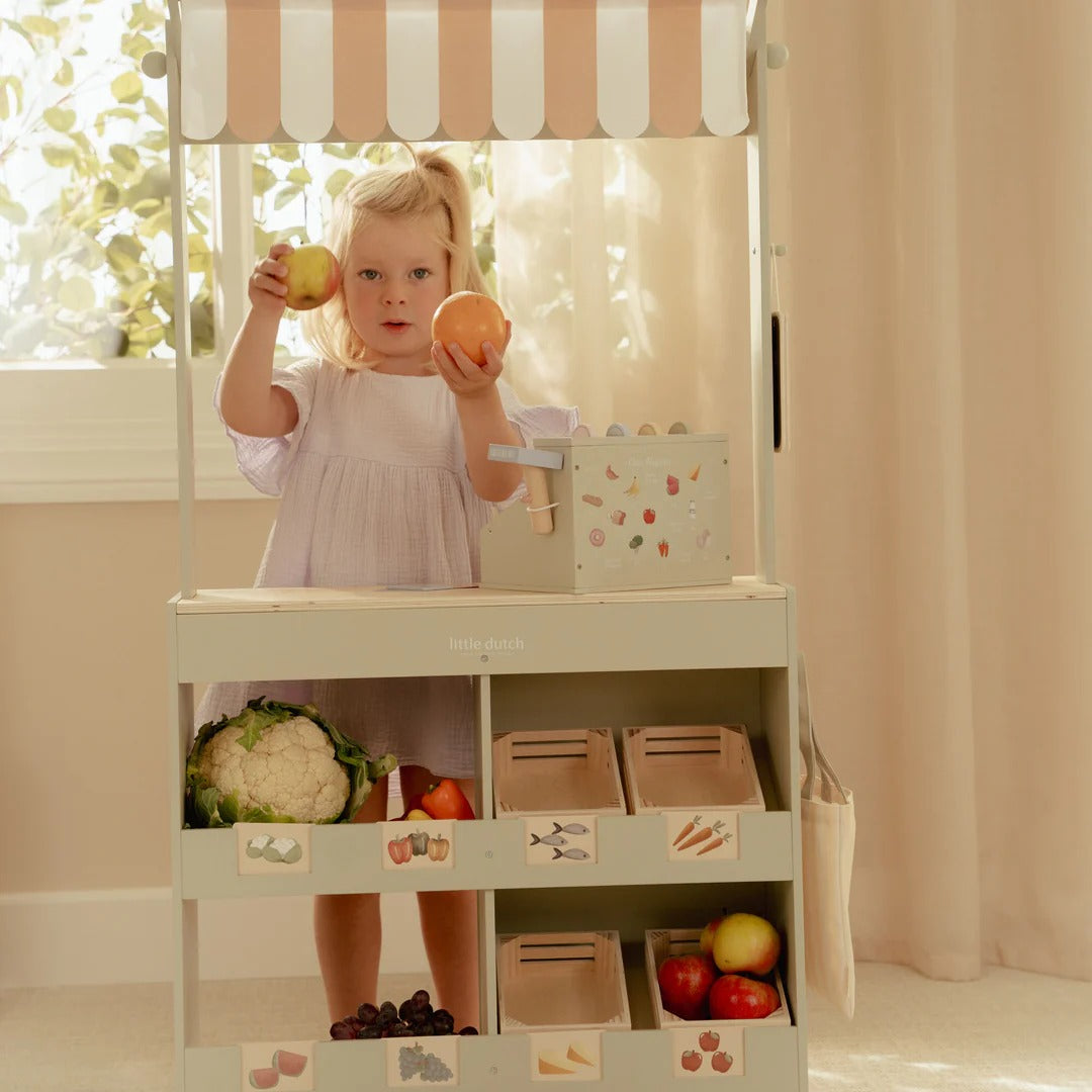 Child playing with a toy kitchen set in a bright room