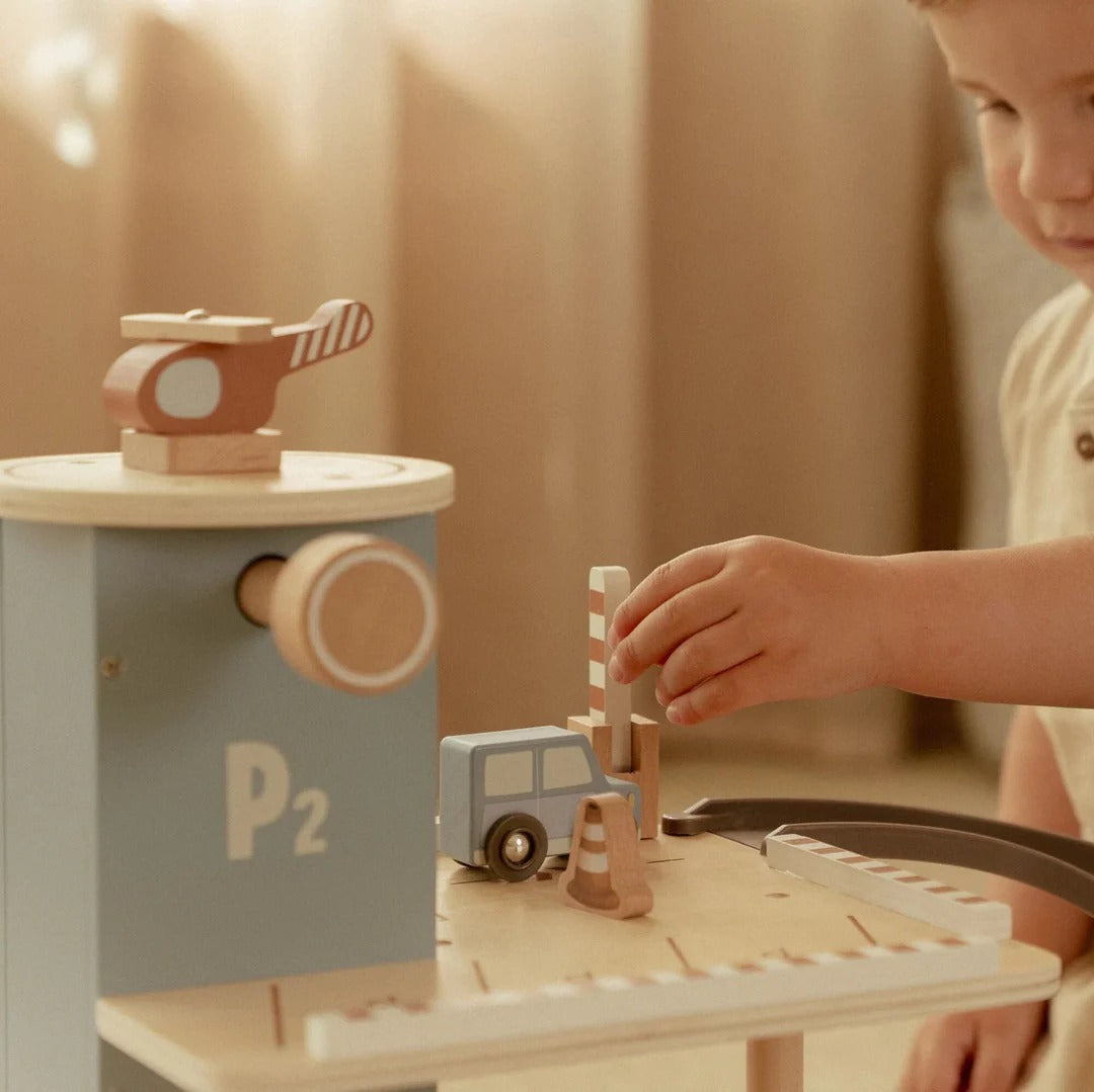 Child playing with a wooden toy set on a wooden table