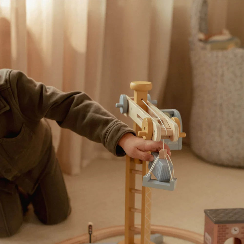 Child playing with a wooden toy train set indoors