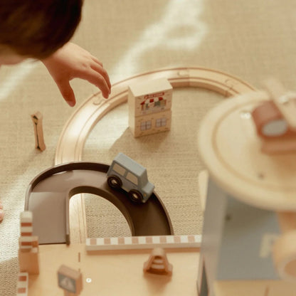 Children playing with a toy train set on a wooden floor