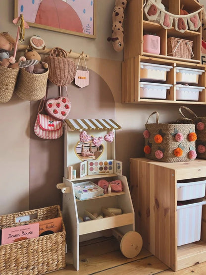 Children's playroom with wooden toys, storage bins, and decorative elements.