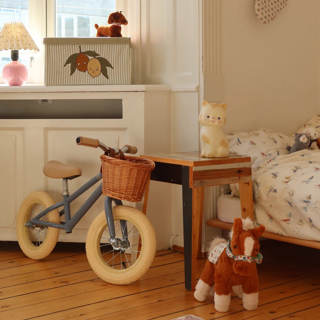 Children's room with a toy bike, plush toys, and a small table.