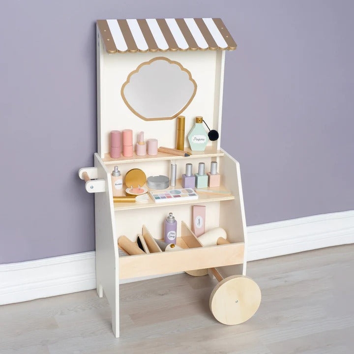 Children's toy makeup vanity with striped canopy against a purple wall.