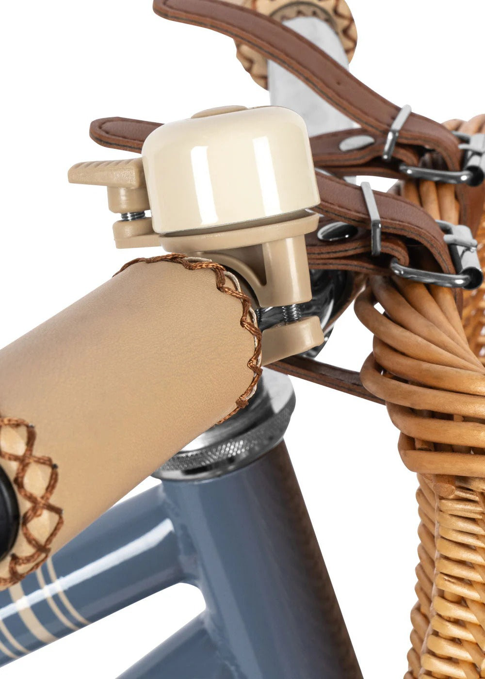 Close-up of a bicycle bell attached to a wicker basket on a bike.