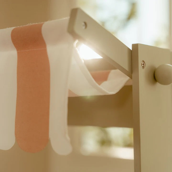 Close-up of a wooden toy with colorful straps on a blurred natural background
