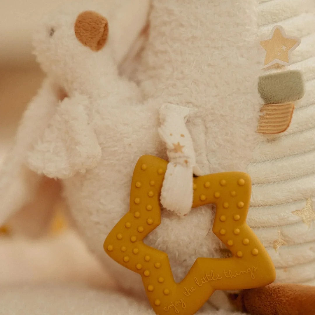 Close-up of a yellow star-shaped teether attached to a plush toy with star patterns.