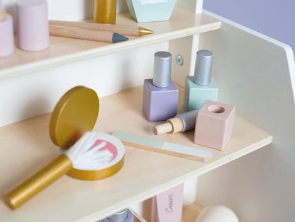 Pastel-colored nail polish bottles and makeup tools on a wooden shelf.
