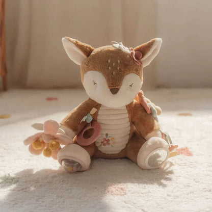 Plush deer toy with flowers on a soft surface