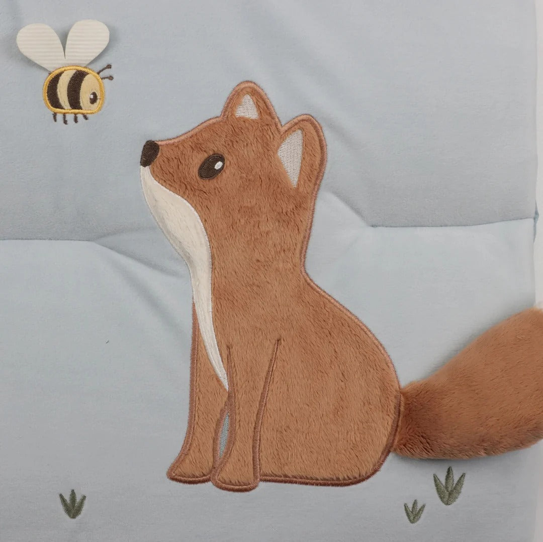 Plush fox toy with a bee and grass on a gray background