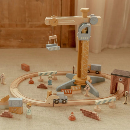 Wooden toy construction set with crane and track on a neutral background